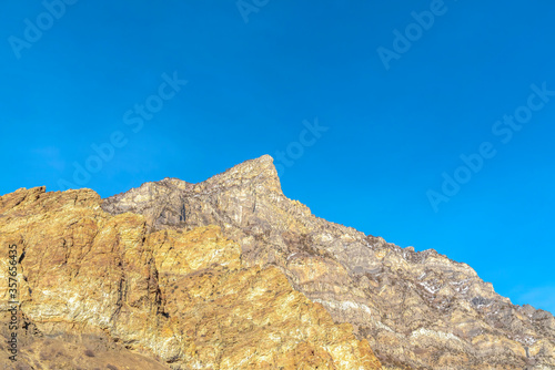 Peak of a steep and rocky mountain in Provo Canyon Utah against clear blue sky