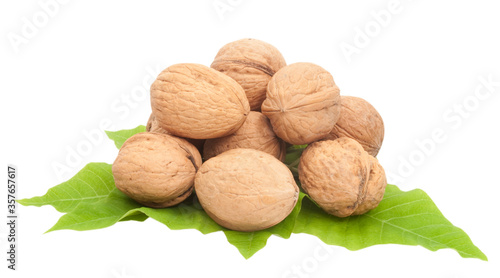 whole walnuts with green leaves isolated on white background