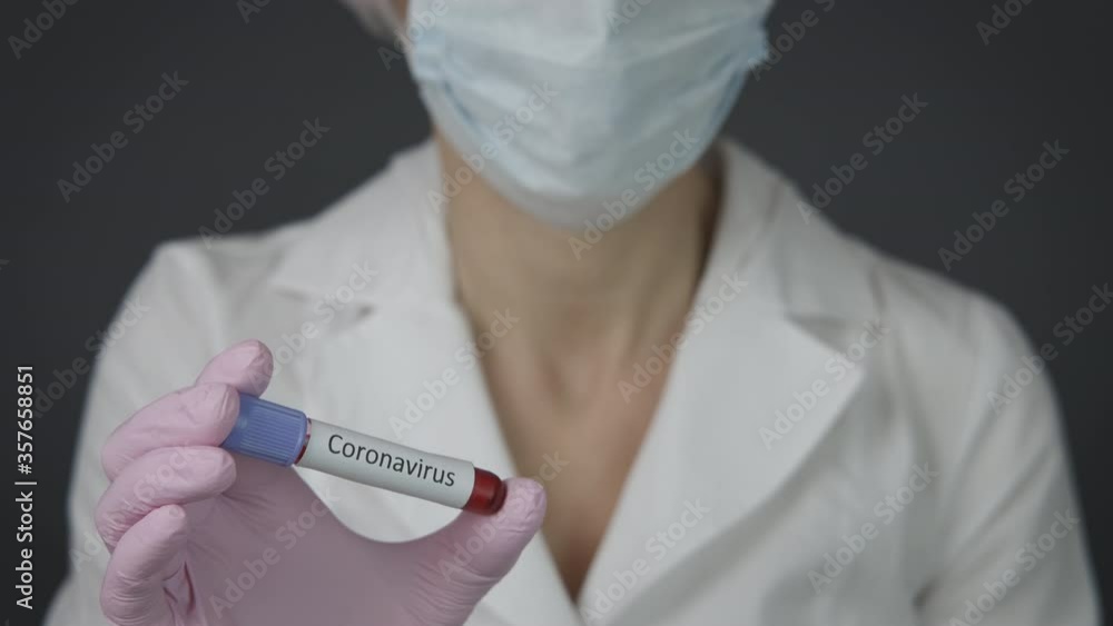 Coronavirus in the lab. Laboratory assistant with a test tube of blood with coronavirus. Coronavirus in the lab. Laboratory assistant with a test tube of blood with coronavirus.