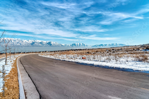 Curvy road amid snowy terrain with scenic Wasatch Mountains and Utah Lake view