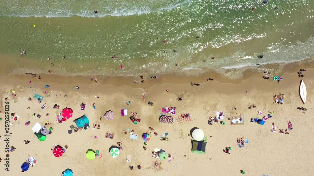Public Beach in mid Summer with Colourful umbrellas, people in the water and on the beach. Drone view.
Public Beach in mid Summer with Colourful umbrellas, people in the water and on the beach. Drone view.