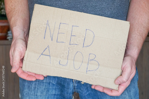 Obraz na płótnie Man in jeans holds a cardboard in his hands search a job w salonie