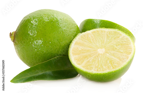 sliced lime with green leaves isolated on white background