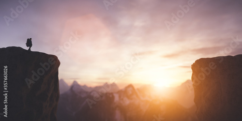 Man on the peak of mountain looking at sunset sky. Trip and adventure. Inspirational. photo