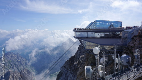 Viewing platform in the Alps with glass architecture. In the front you can see the radio station with antenna mast and satellite system. Zugspitze, mountain in Germany, highest peak. photo