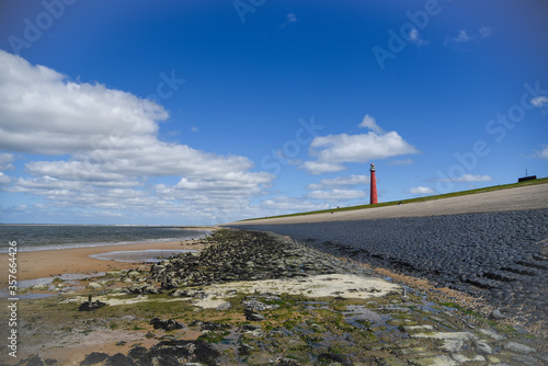 Den Helder, the Netherlands - May 2020. Lighthouse 'Lange Jaap' in Huisduinen at low tide. photo