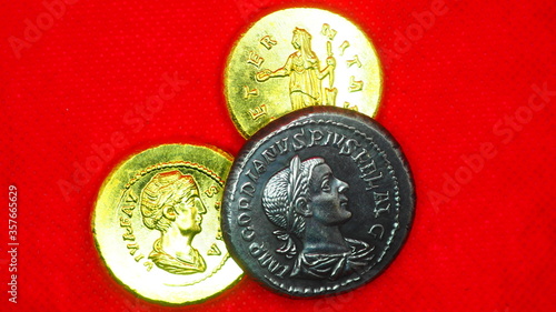 Silver and gold roman coins on red background photo
