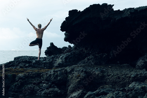 Athlete man practicing yoga outdoors photograph