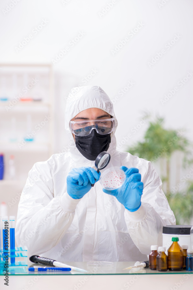 Young male chemist working in medicine lab Young male chemist working in medicine lab