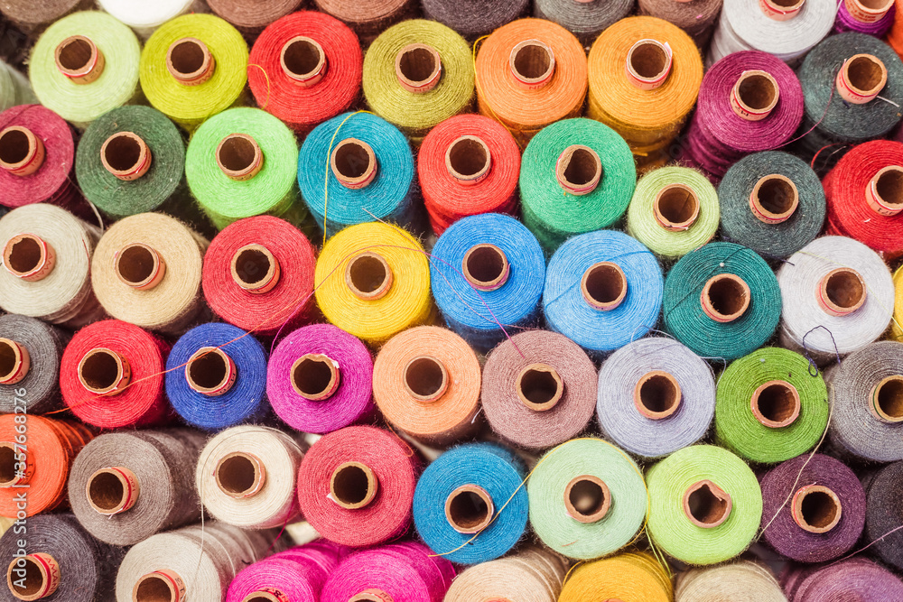 Fototapeta premium Threads in a tailor textile fabric: colorful cotton threads, birds eye perspective