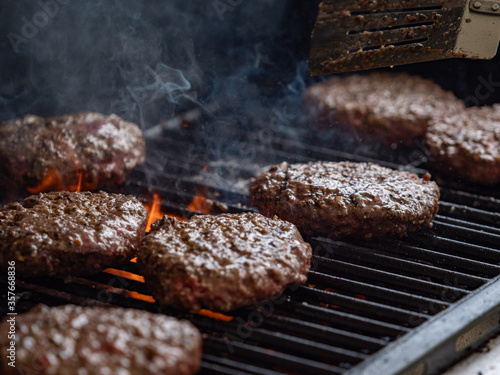 burgers cooking on an open flame grill top