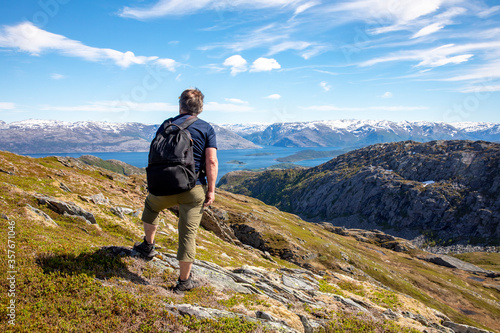 Happy man on hike to the Skogmo mountain in great summer weather, Nordland county