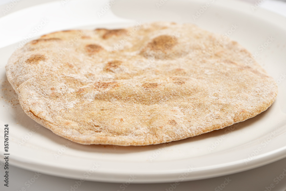 Flatbread on a white plate close-up Flatbread on a white plate close-up