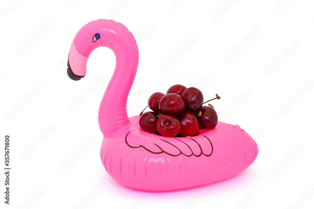 Isolated pink inflatable flamingo with red ripe cherry on white background Isolated pink inflatable flamingo with red ripe cherry on white background