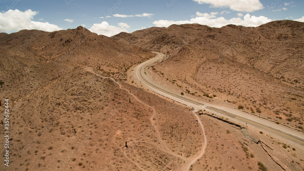 Travel. Aerial view of the desert asphalt route crossing the arid mountains in Los Cardones National Park. Travel. Aerial view of the desert asphalt route crossing the arid mountains in Los Cardones National Park.