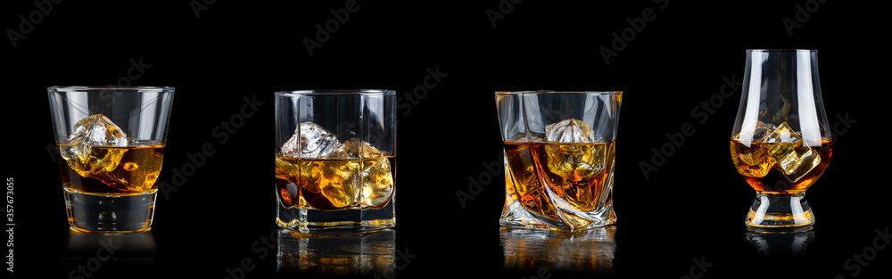 Set of four glass of whiskey with cube ice on black background