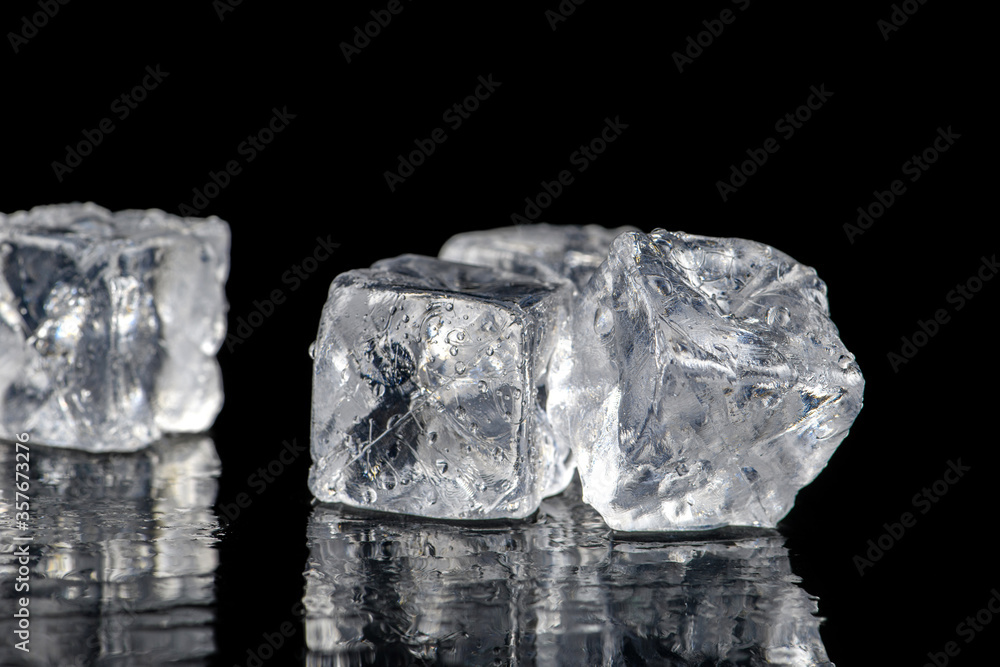 Obraz premium Ice cubes reflection on black table background