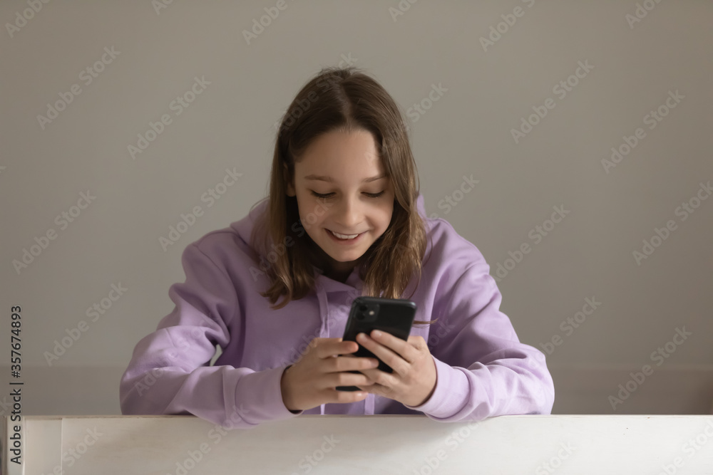 Smiling teenage girl browse surf wireless internet on modern smartphone gadget at home, happy teenager kid using cellphone, texting messaging on device, connection, technology concept Smiling teenage girl browse surf wireless internet on modern smartphone gadget at home, happy teenager kid using cellphone, texting messaging on device, connection, technology concept
