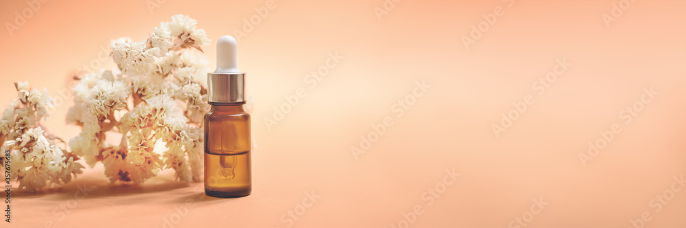 A glass dropper bottle on the orange background. A glass dropper bottle on the orange background.