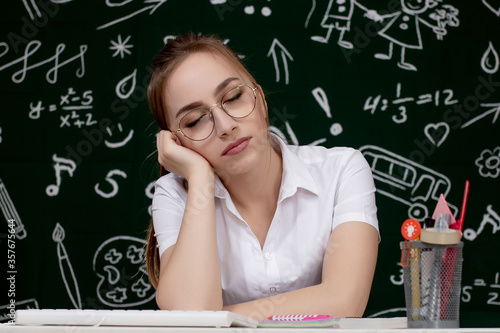 Young female student sleeping in a classroom