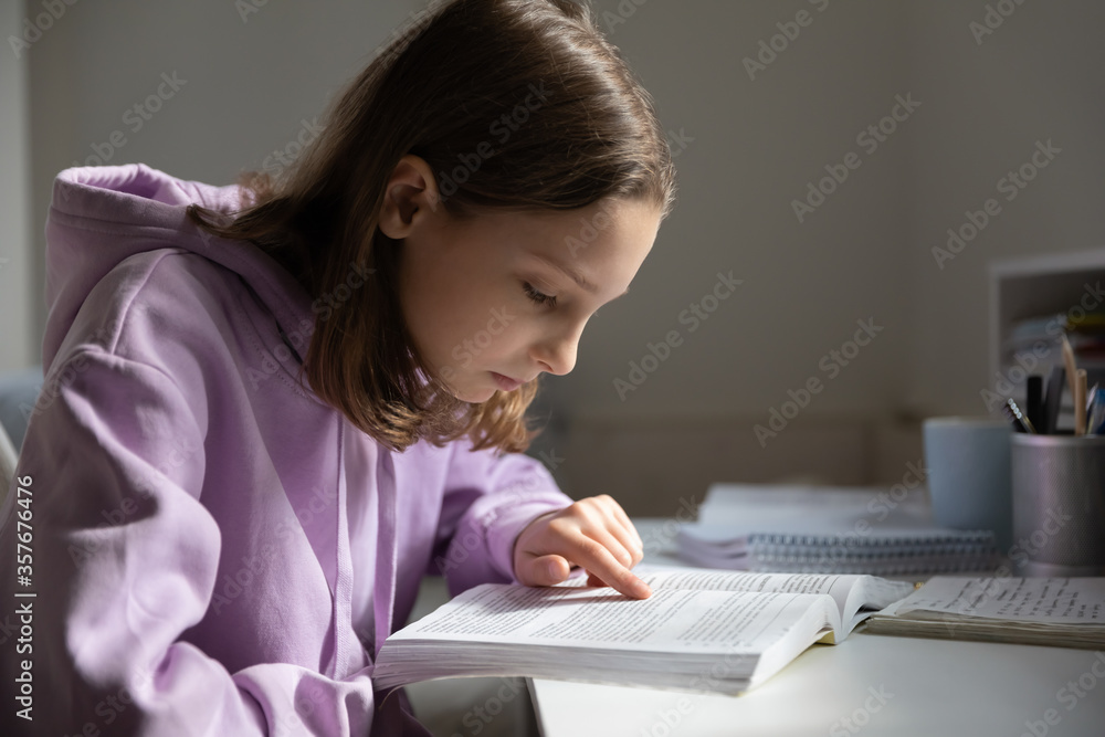 Focused smart teenage schoolgirl sit at desk at home reading textbook do prepare homework, concentrated teenager girl pupil learning studying with book in bedroom, education, school concept Focused smart teenage schoolgirl sit at desk at home reading textbook do prepare homework, concentrated teenager girl pupil learning studying with book in bedroom, education, school concept