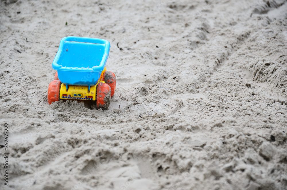 Yellow and blue plastic toy truck and sand Yellow and blue plastic toy truck and sand