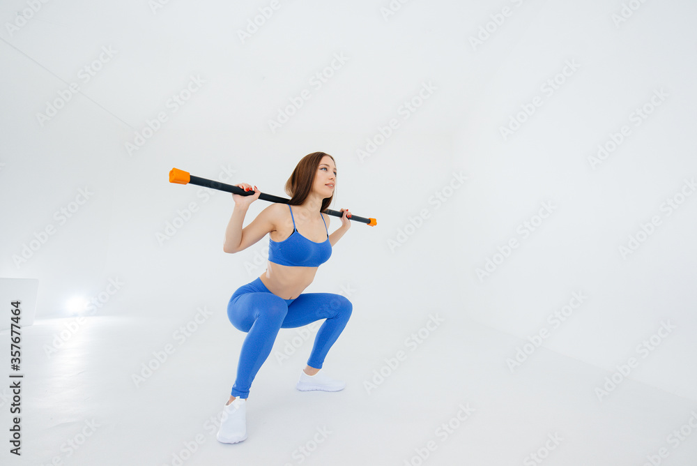 Sexy young girl performs sports exercises on a white background. Fitness, healthy lifestyle Sexy young girl performs sports exercises on a white background. Fitness, healthy lifestyle