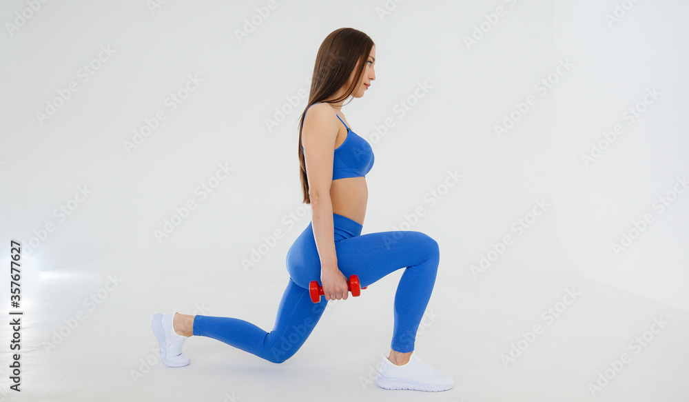 Sexy young girl performs sports exercises on a white background. Fitness, healthy lifestyle Sexy young girl performs sports exercises on a white background. Fitness, healthy lifestyle