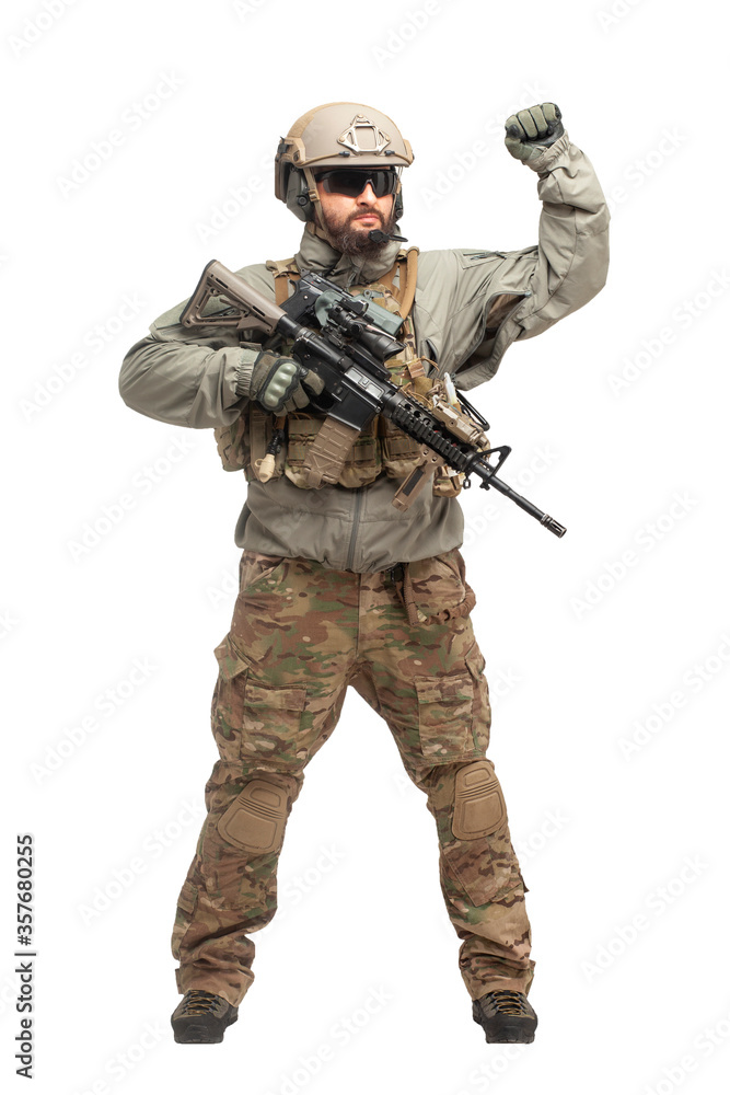 American ranger in military equipment and with a rifle shows a hand gesture on a white background, portrait of a special forces soldier with a weapon American ranger in military equipment and with a rifle shows a hand gesture on a white background, portrait of a special forces soldier with a weapon