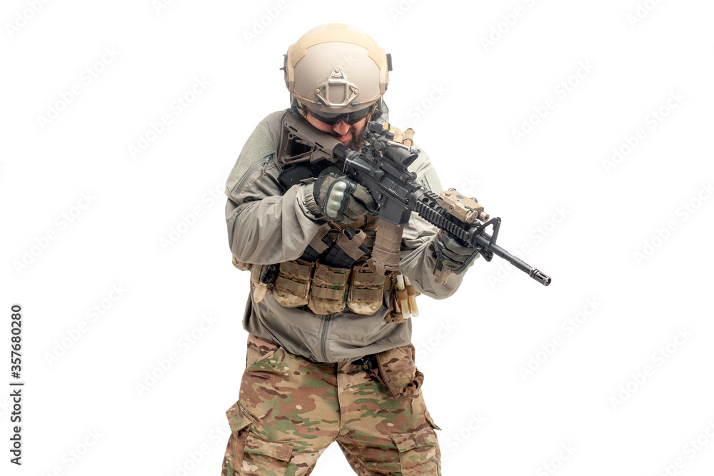 American soldier in uniform and with a rifle aiming and shoots, commando with guns on a white background