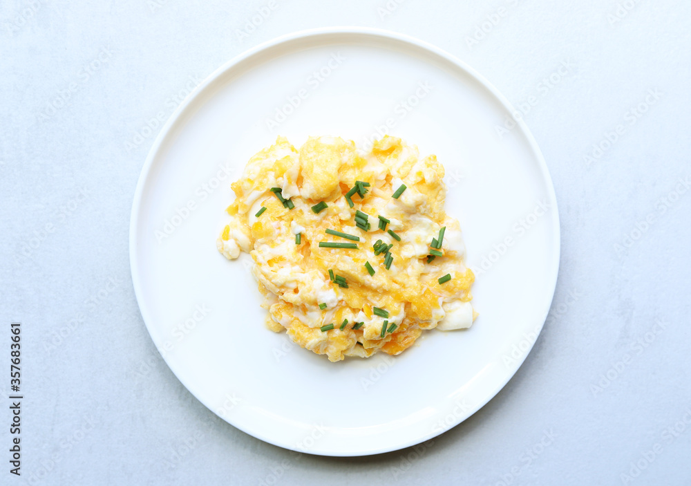 Fototapeta premium Scrambled eggs on a white plate. Healthy food or breakfast concept.