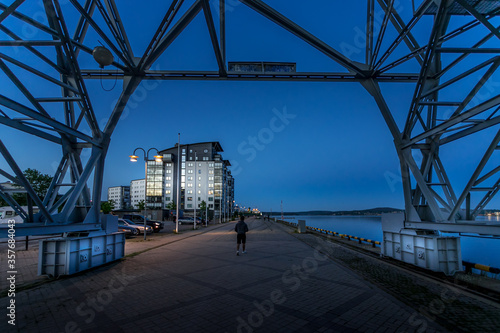 A person is walking under crane in the port