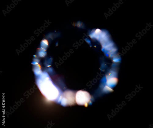 Lens Flare, Abstract Bokeh Lights. Leaking Reflection of a Glass, Diamond, Crystal. Jewelry. Defocused Shining round shaped Colorful rainbow Light Leaks, Rays on Black Background