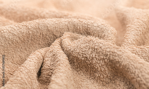 Towel texture closeup. Soft beige color cotton towel backdrop, fabric background. Terry cloth bath or beach towels. Macro image