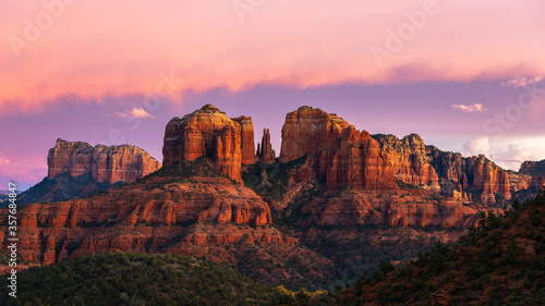 Cathedral Rock in Sedona, Arizona during a beautiful sunset with pink skies and clouds. 