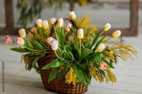 bouquet of tulips and mimosa in a basket