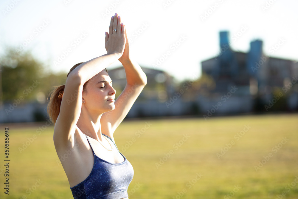 Young sportive woman doing yoga fitness exercises on warm summer day outdoors. Young sportive woman doing yoga fitness exercises on warm summer day outdoors.