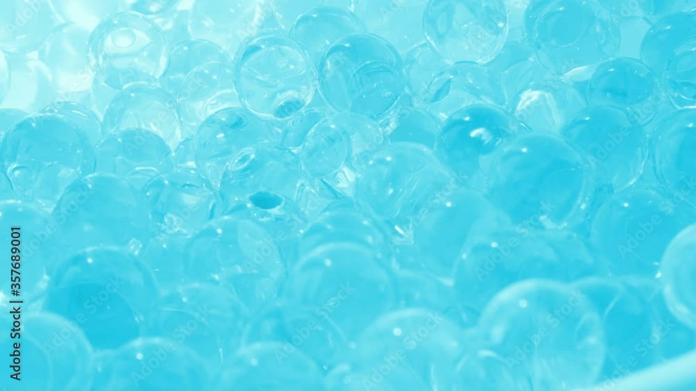 Glass balls of bluish glass. Smooth rotation. Hydrogel and beads. Macro video Glass balls of bluish glass. Smooth rotation. Hydrogel and beads. Macro video