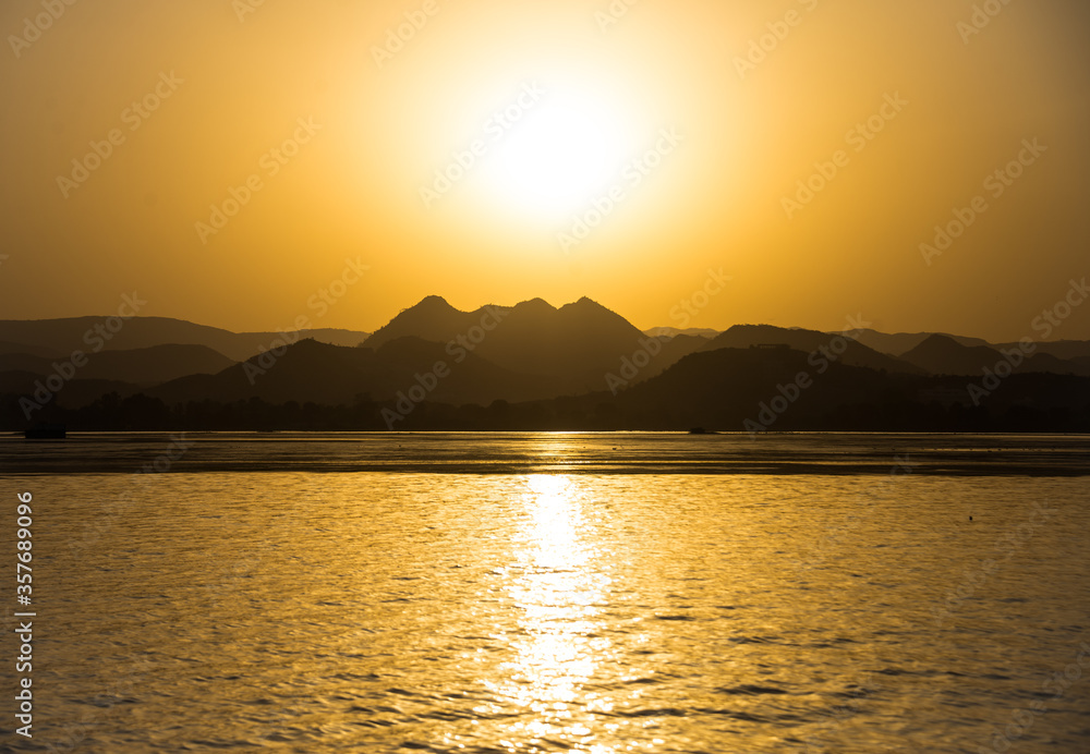 Sunset over the mountains in Udaipur, India from Lake Pichola.