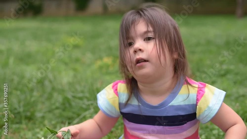 Girl playing with a flower on a windy day