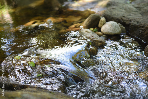 Crystal-clear running water with stones in the mountains.