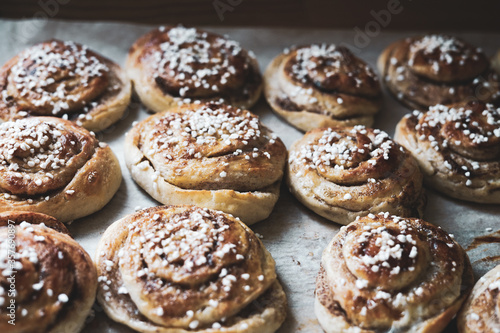 Batch of freshly baked homemade Swedish style cinnamon rolls / buns with pearl sugar. Slightly increased contrast, vintage style photo -Image