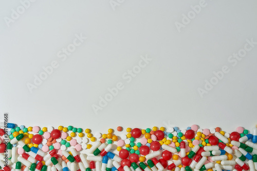 Different pills, capsules scattered horizontally over white background. Health care, vitamins and treatment concept