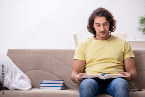 Young male student preparing for exams at home