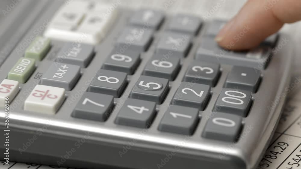 Cropped shot of an unrecognizable businessman working out his finances with a calculator and a documents in his office Cropped shot of an unrecognizable businessman working out his finances with a calculator and a documents in his office