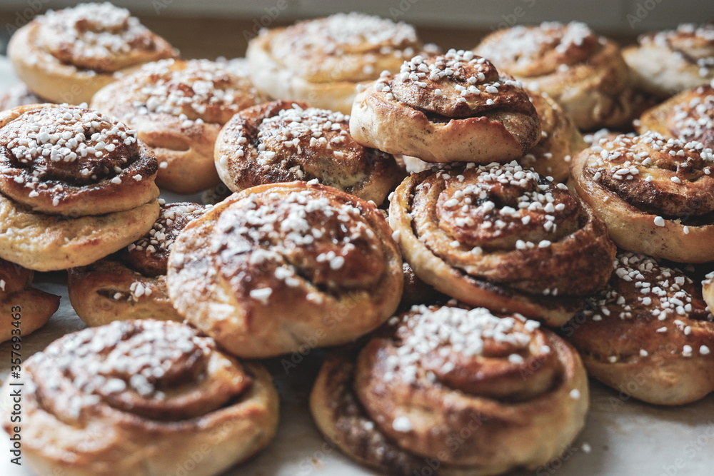 Batch of freshly baked homemade Swedish style cinnamon rolls / buns with pearl sugar. Slightly increased contrast, vintage style photo -Image