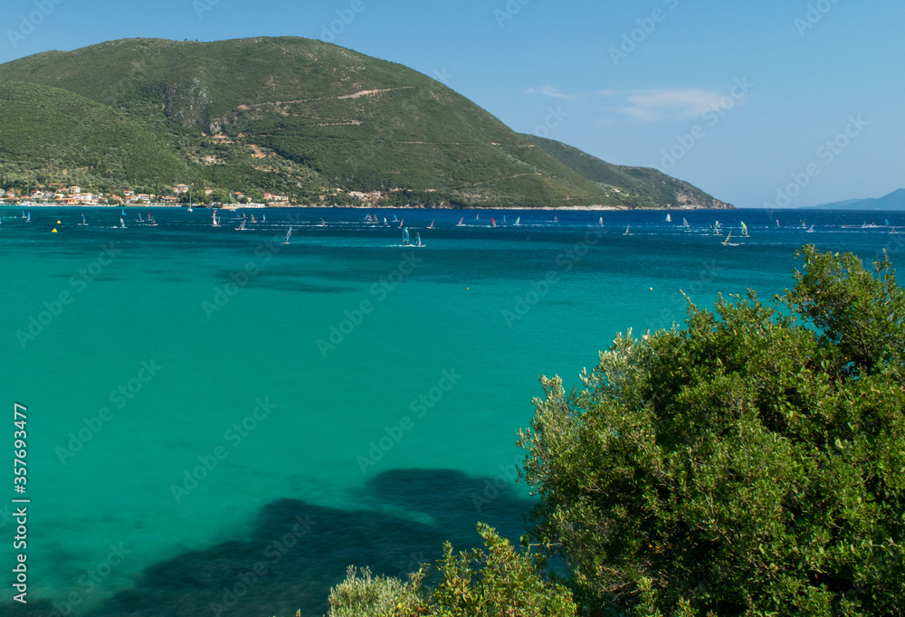 People enjoying windsurf on turquoise sea during summer in Lefkada island, Greece