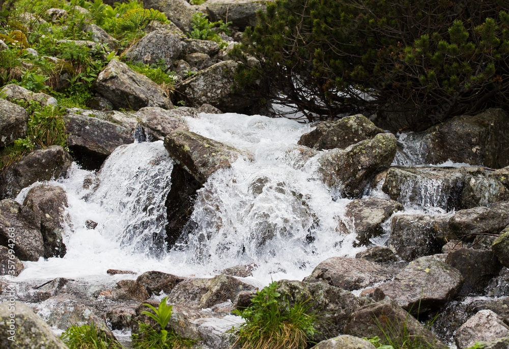 Mountain waterfall, visible flowing water bouncing on the rocks. Mountain waterfall, visible flowing water bouncing on the rocks.