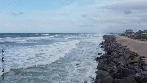 Ocean coastline follow along as waves crash into the rocky barriers