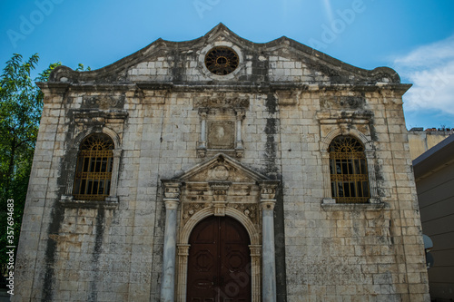 Abandoned orthodox church with large wooden front door and neoclassical architecture in Lefkada
